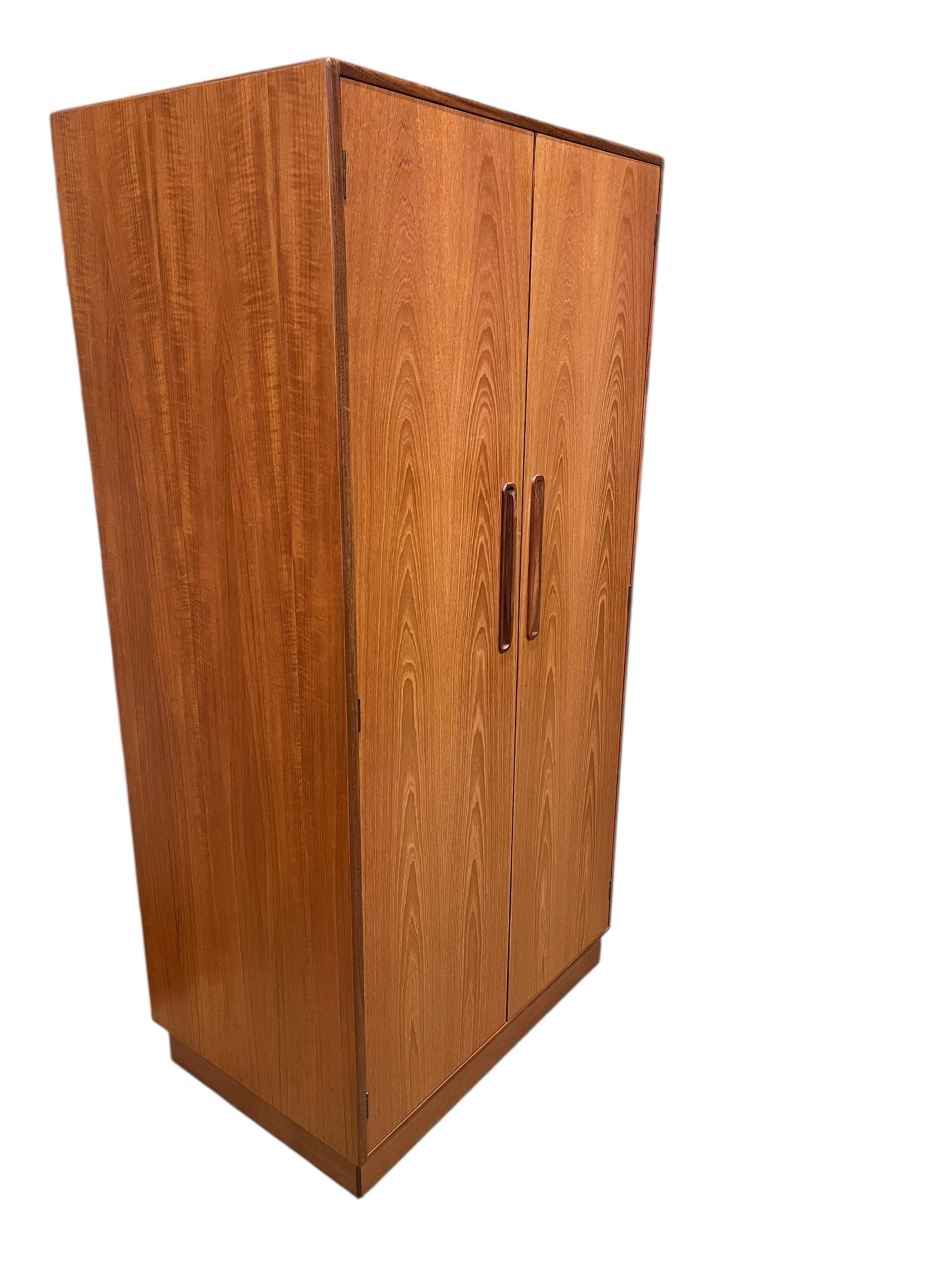 A mid century G Plan Fresco teak bedroom suite comprising a three door wardrobe, a two door wardrobe, two six drawer chests, dressing table, headboard and a pair of bedside chests